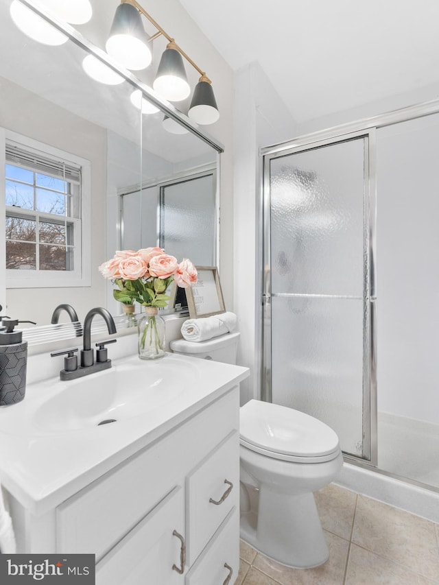 full bathroom with tile patterned flooring, a shower stall, toilet, and vanity