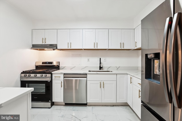 kitchen with a sink, marble finish floor, under cabinet range hood, and stainless steel appliances