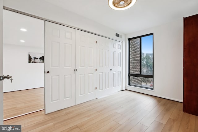 unfurnished bedroom featuring light wood-type flooring, visible vents, recessed lighting, a closet, and baseboards