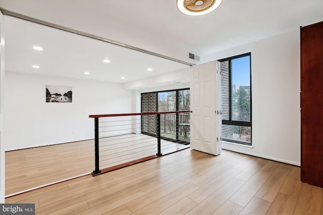 unfurnished room featuring recessed lighting, wood finished floors, visible vents, and baseboards