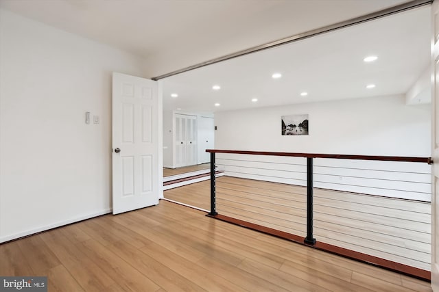 spare room with recessed lighting, light wood-type flooring, and baseboards