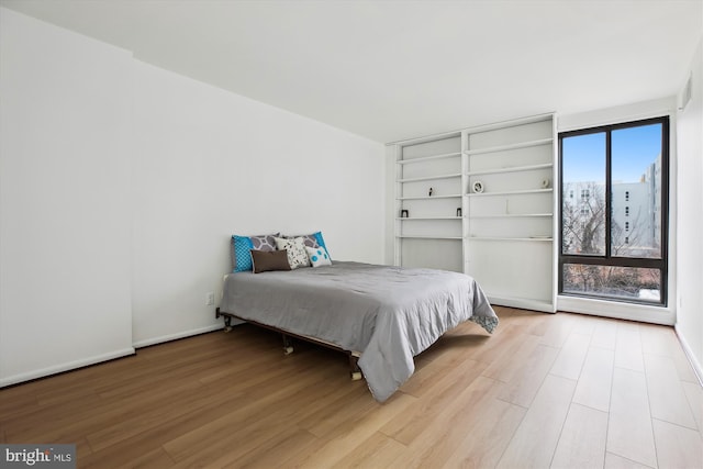 bedroom featuring light wood-style flooring and baseboards