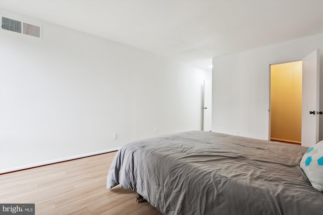 bedroom featuring visible vents, baseboards, and wood finished floors