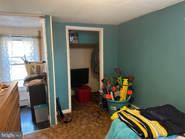 bedroom with baseboards, a closet, and baseboard heating