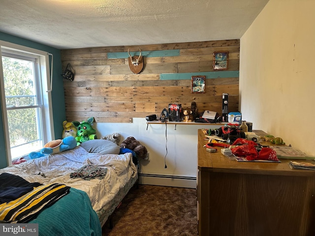 bedroom featuring baseboard heating, dark carpet, a textured ceiling, and wooden walls