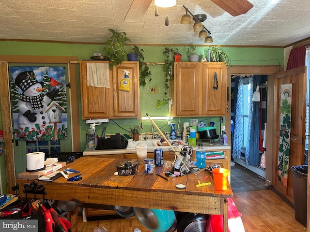 kitchen with wood finished floors, a ceiling fan, and light countertops