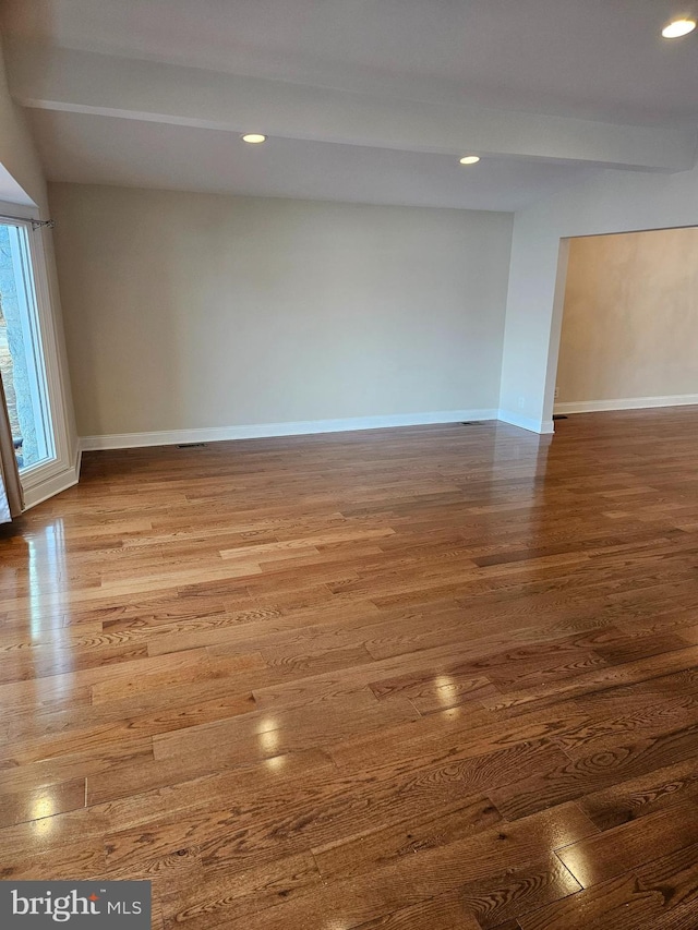 unfurnished room with baseboards and wood finished floors