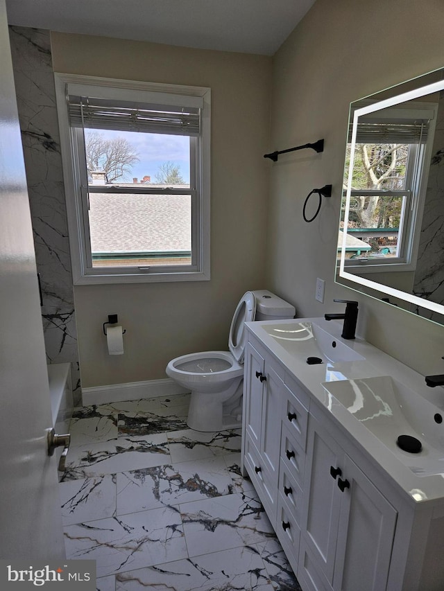 bathroom with a sink, baseboards, toilet, and marble finish floor