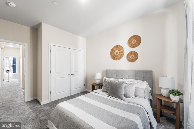 carpeted bedroom with a closet and baseboards