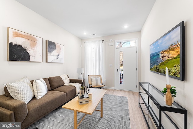 living room with recessed lighting, visible vents, and light wood finished floors