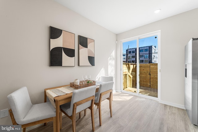 dining area featuring light wood-type flooring and baseboards
