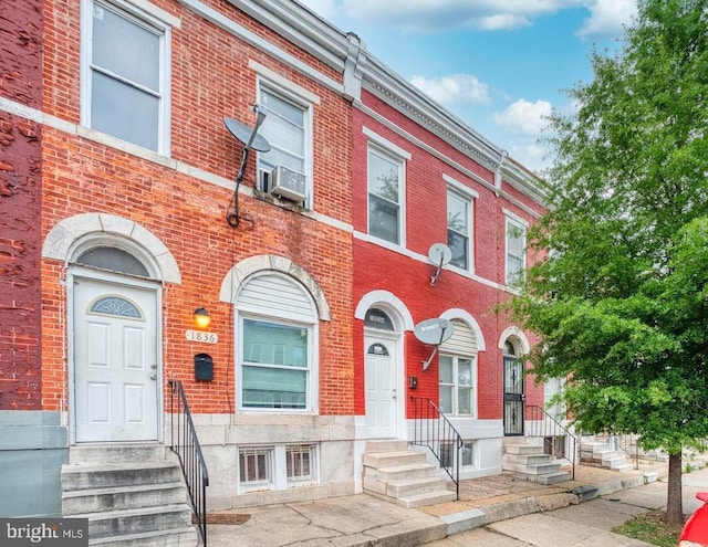 view of front of property featuring cooling unit, brick siding, and entry steps