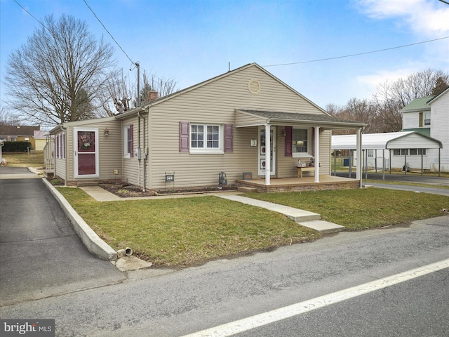 view of front of property with a detached carport, covered porch, a chimney, and a front lawn