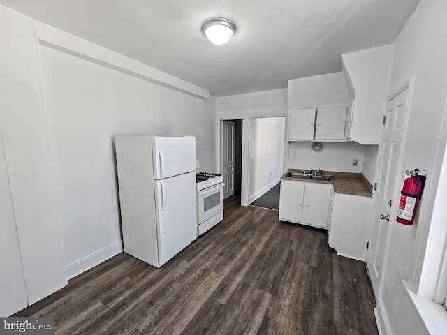 kitchen with dark wood-style flooring, white cabinets, white appliances, and a sink