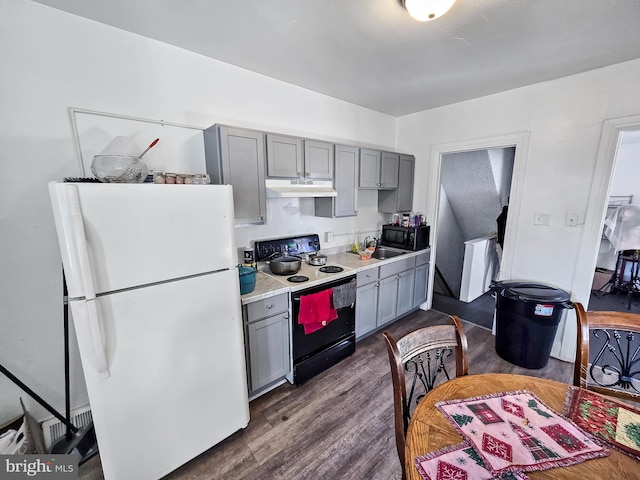 kitchen with under cabinet range hood, range with electric stovetop, gray cabinets, and freestanding refrigerator