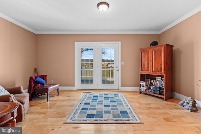 sitting room featuring baseboards, light wood-style floors, and ornamental molding