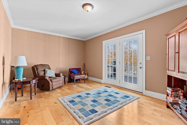 sitting room with light wood-style floors, baseboards, and ornamental molding