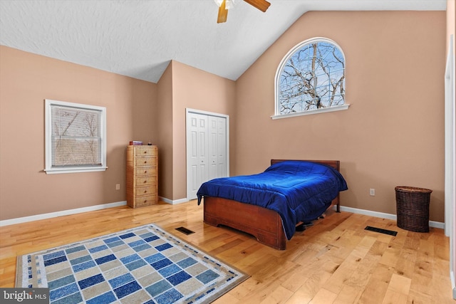 bedroom featuring lofted ceiling, wood finished floors, visible vents, and a closet