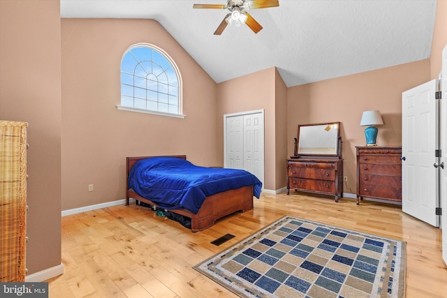 bedroom featuring vaulted ceiling, wood finished floors, a closet, and baseboards