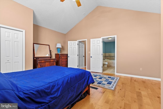 bedroom featuring connected bathroom, baseboards, wood finished floors, a closet, and a ceiling fan