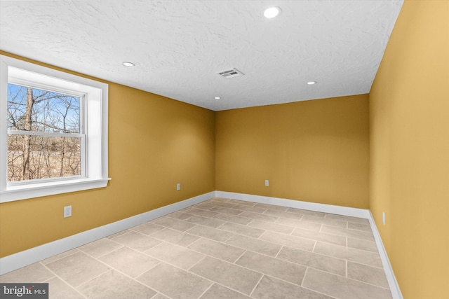 unfurnished room with visible vents, baseboards, light tile patterned floors, recessed lighting, and a textured ceiling