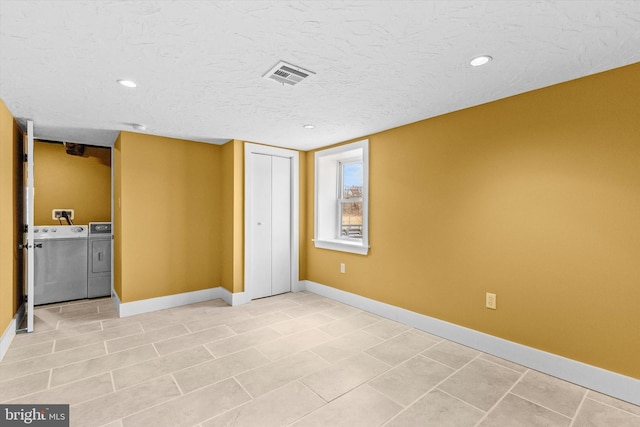 unfurnished bedroom with washing machine and clothes dryer, visible vents, a textured ceiling, and baseboards