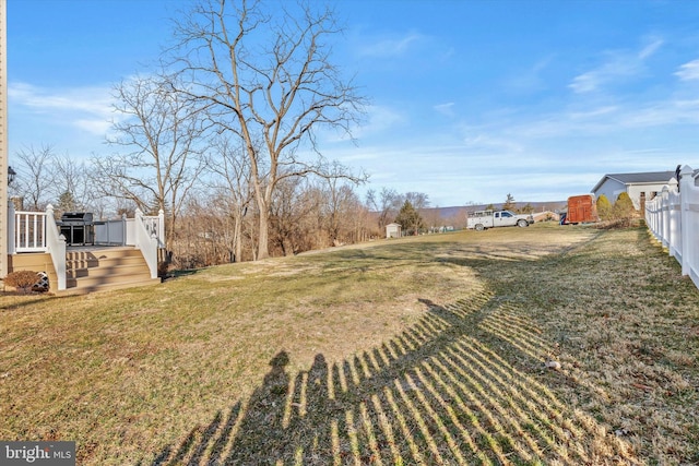 view of yard featuring a deck and fence