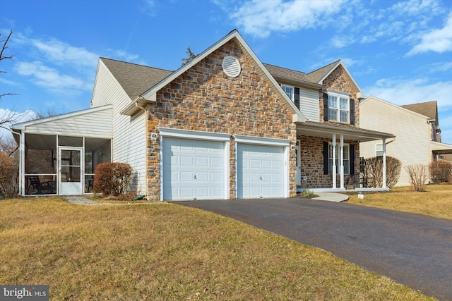 view of front of property with a front yard, a garage, a sunroom, stone siding, and driveway