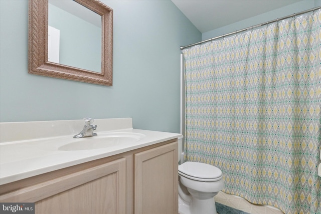 bathroom with curtained shower, toilet, and vanity