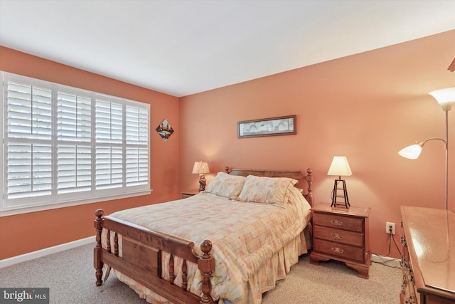 bedroom with light colored carpet and baseboards