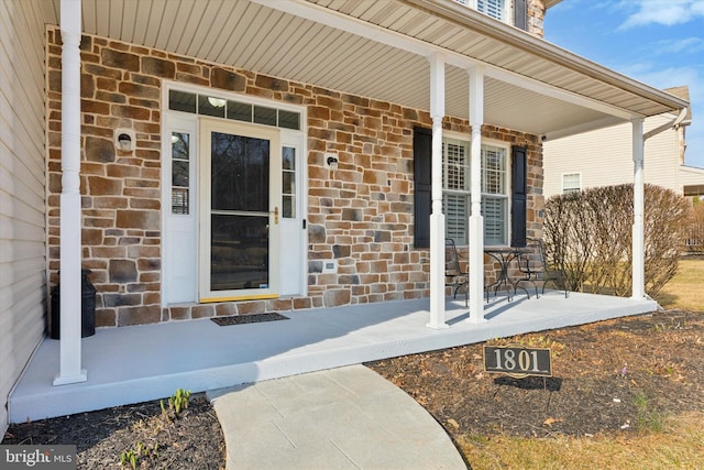 entrance to property with brick siding and covered porch