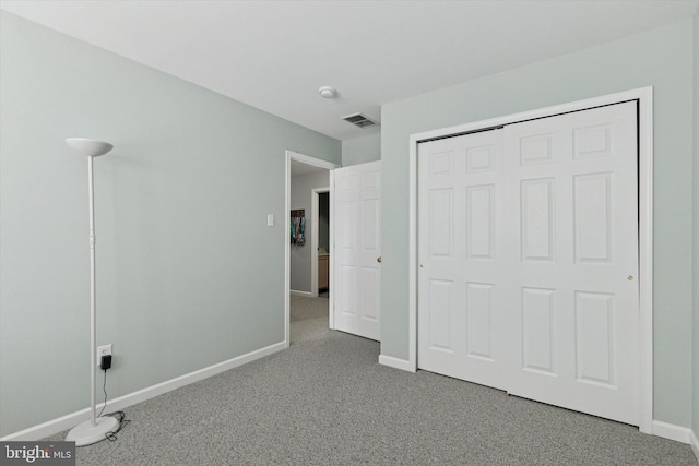 unfurnished bedroom featuring visible vents, baseboards, a closet, and carpet flooring