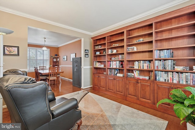 living area with wood finished floors and crown molding