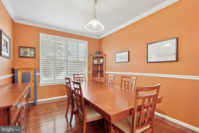 dining area featuring baseboards, wood finished floors, and ornamental molding