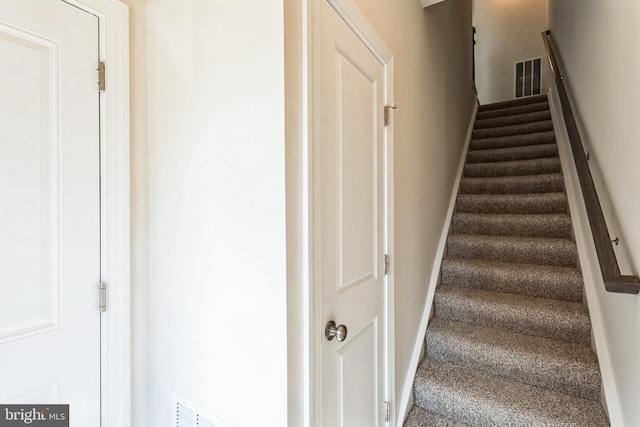 stairway with baseboards and visible vents