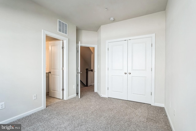 unfurnished bedroom with a closet, visible vents, baseboards, and carpet floors