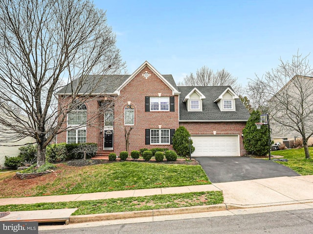 view of front of property featuring a front lawn, brick siding, and driveway