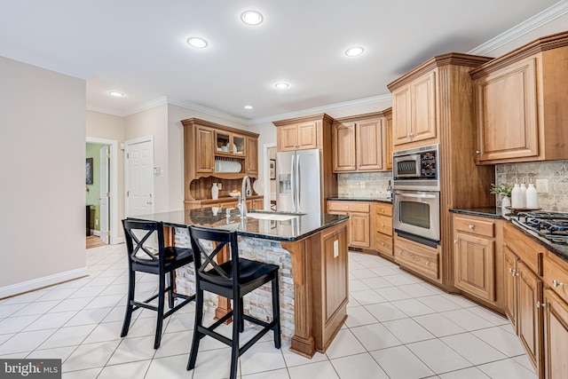 kitchen featuring light tile patterned floors, a breakfast bar area, stainless steel appliances, and a sink