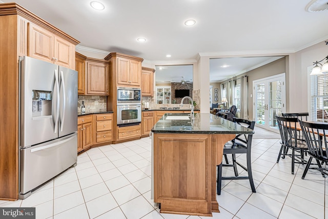 kitchen with a sink, stainless steel appliances, a breakfast bar, and light tile patterned flooring