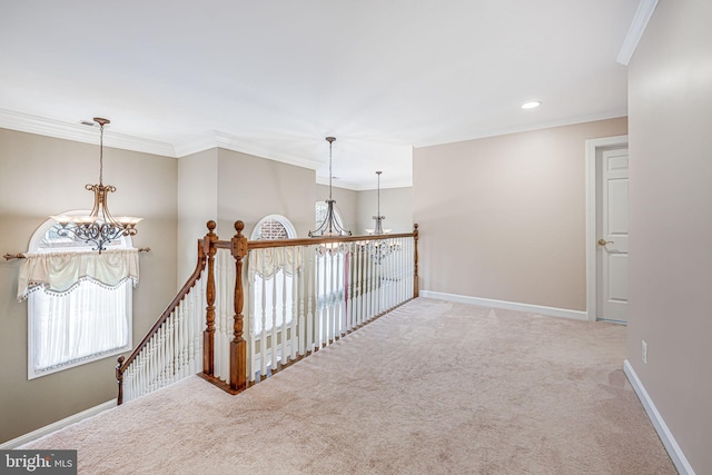 hall featuring an inviting chandelier, crown molding, and baseboards