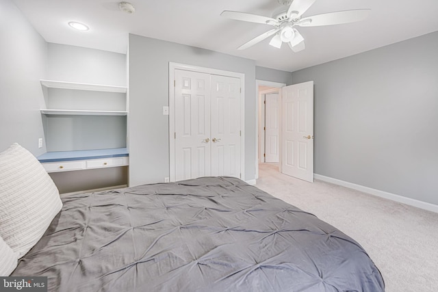 carpeted bedroom featuring a closet, baseboards, and ceiling fan