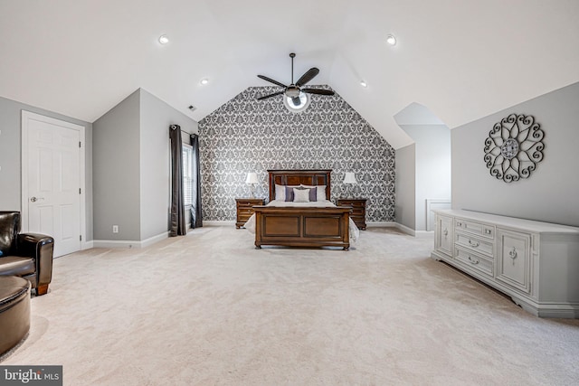 bedroom featuring light colored carpet, an accent wall, baseboards, and vaulted ceiling