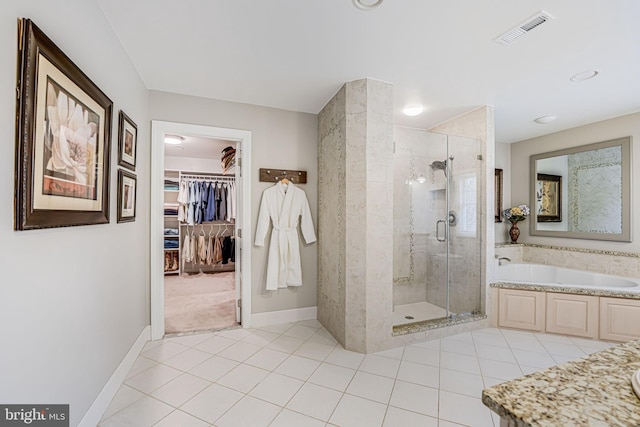 full bath featuring a walk in closet, a shower stall, a garden tub, and visible vents