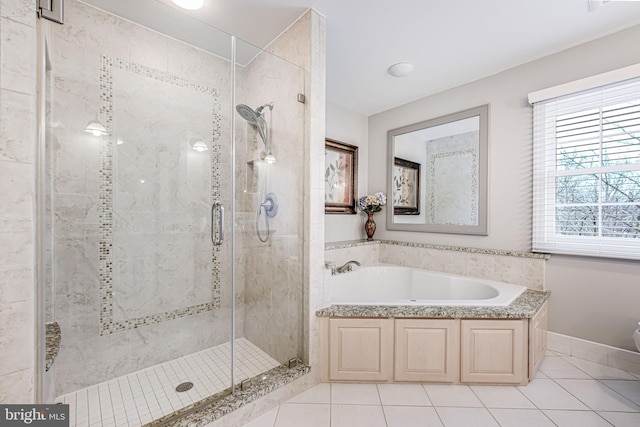 full bathroom with tile patterned flooring, a garden tub, and a stall shower