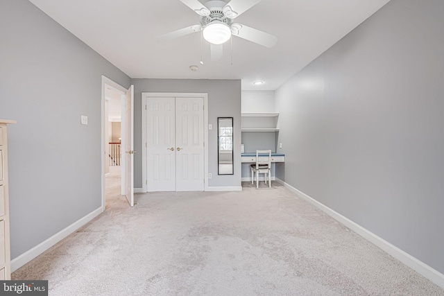 unfurnished bedroom featuring a ceiling fan, carpet, baseboards, and a closet