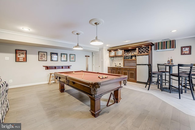 game room featuring light wood finished floors, wet bar, pool table, and crown molding