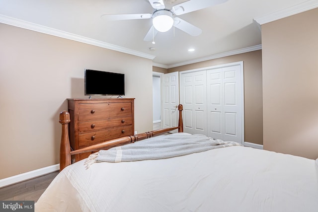 bedroom with ornamental molding, wood finished floors, a closet, baseboards, and ceiling fan