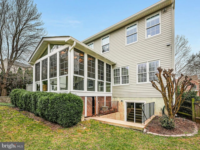 back of house with a yard and a sunroom