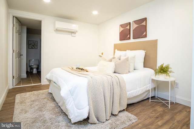 bedroom featuring recessed lighting, wood finished floors, and a wall mounted AC