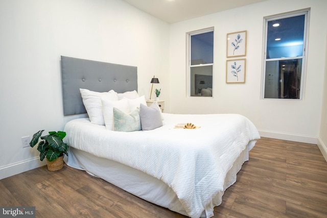 bedroom with baseboards and wood finished floors